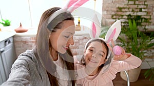 Mother and daughter wearing bunny ears doing selfie