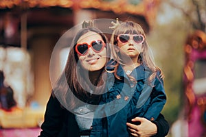 Mother and Daughter Wearing Matching Heart Shape Sunglasses and Crowns