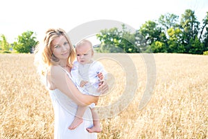 Mother and daughter in wheat field. Happy Family outdoors. healthy child with mother on picnic with bread and milk in golden