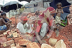 Mother and daughter working as stone breakers