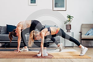 Mother and daughter working out at home, doing exercises
