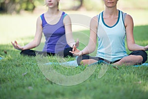 Mother and daughter with yoga exercise outdoors at the park. Health and Fitness concept