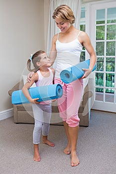 Mother and daughter with yoga mats