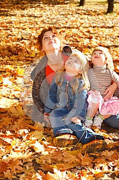 Mother and daughters in autumn leaves