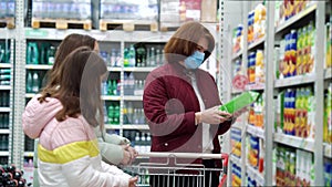 Mother and daughters buying juice at grocery store during pandemic