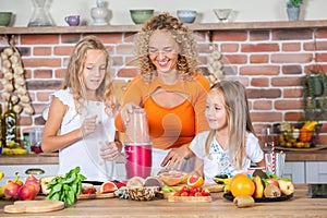 Mother and daughters cooking together in the kitchen. Healthy food concept.