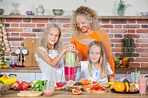 Mother and daughters cooking together in the kitchen. Healthy food concept.