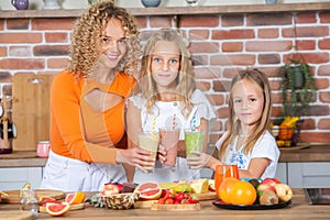 Mother and daughters cooking together in the kitchen. Healthy food concept.