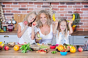 Mother and daughters cooking together in the kitchen. Healthy food concept.