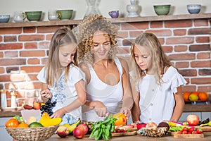 Mother and daughters cooking together in the kitchen. Healthy food concept.