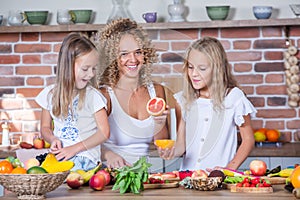 Mother and daughters cooking together in the kitchen. Healthy food concept.