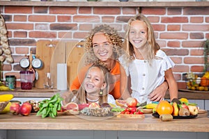 Mother and daughters cooking together in the kitchen. Healthy food concept.