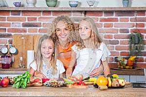 Mother and daughters cooking together in the kitchen. Healthy food concept.