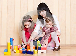 Mother and daughters play with toys