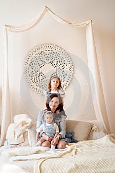 Mother with daughters playing on bed. photo shoot.