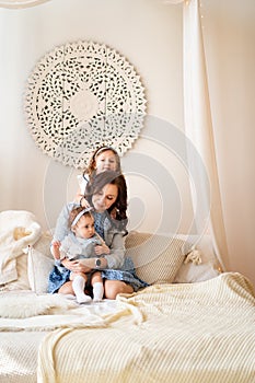 Mother with daughters playing onbed. photoshoot.