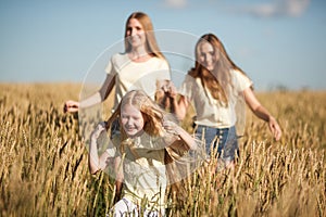 Mother and daugthers run on wheat filed