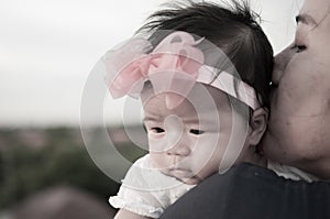 Mother day bonding concept with newborn baby nursing. Mother is holding newborn baby with flower pink headband with blue sky.