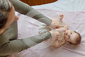 Mother does back and a foot massage to a newborn baby. mother`s care. healthy lifestyle