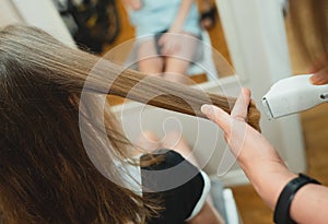 Mother doing haircut to her daughter.