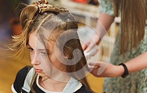 Mother doing haircut to her daughter.