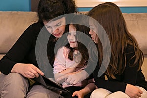 Mother doing lessons with children on a tablet