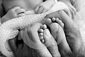 Mother is doing massage on her baby foot. Close up baby feet in mother hands.