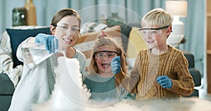 Mother doing a science project with her children in the living room with lab equipment at home. Wow, excited and happy