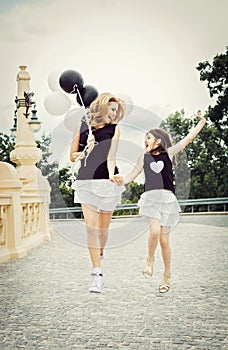 Mother with doughter having a fun with baloons