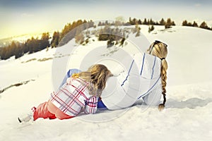 Mother and doughter resting on the snow