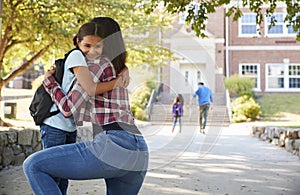 Mother Dropping Off Daughter In Front Of School Gates