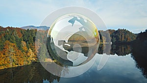 Mother earth concept, world globe above a calm autumn lake