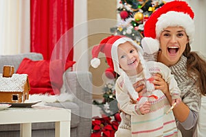 Mother and eat smeared baby in Christmas hats