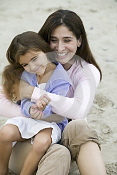 Mother embracing daughter on beach