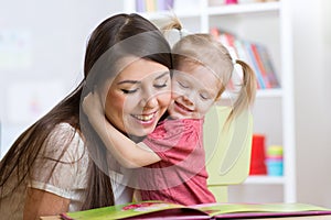 Mother embracing and reading a book to kid at home