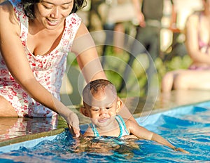 Mother Encourage Toddler Having Fun at Swimming Pool