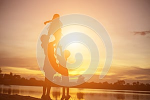 Mother encouraged her son outdoors at sunset, silhouette concept