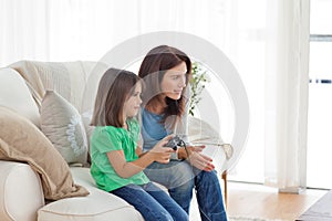 Mother encouraging her daughter playing video game