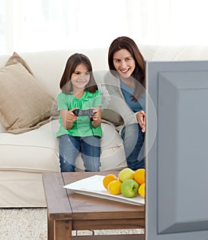 Mother encouraging her daughter playing video game