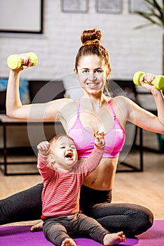 Mother exercising with her baby son at home