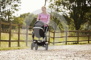 Mother Exercising By Running Whilst Pushing Baby Buggy