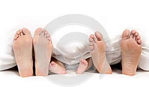 Mother Father and Baby Feet under Blanket