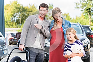 Mother, father, and child buying car at dealership