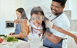 Mother, father and child play while cooking in the kitchen bonding, laughing and having fun happy family home, Smile