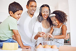 Mother, father and children learning baking as a happy family together teaching siblings to bake cakes. Mom, dad and