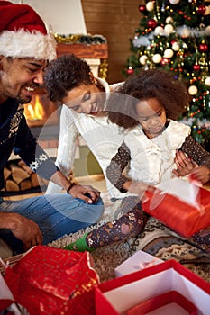 Mother, father and daughter in Christmas morning opening present