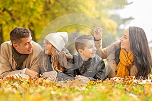 Mother, father, daughter, and son enjoying togetherness outdoors on a colorful fall day