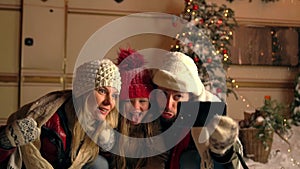 Mother, father, daughter taking selfie at snowing weather.