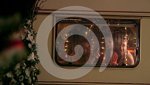 Mother, father, daughter waiting for Santa Claus waiting in window for present