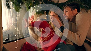 Mother, father, daughter waiting for Santa Claus waiting in window for present